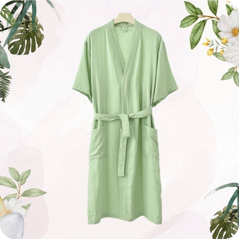 Light green robe with a belt on a white background with decorative plants.