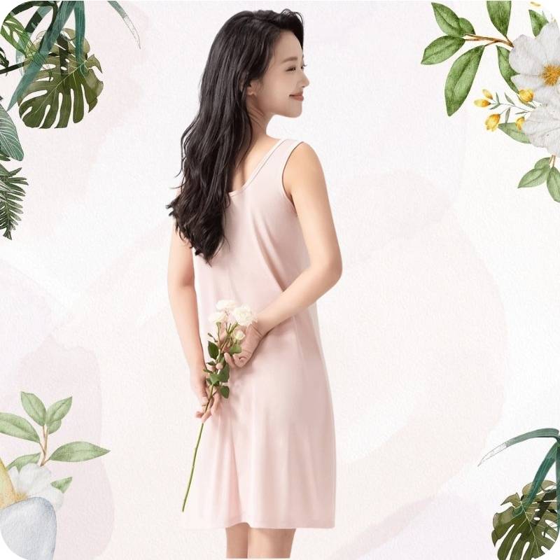 Woman in a light pink dress holding flowers with floral decorations on a white background