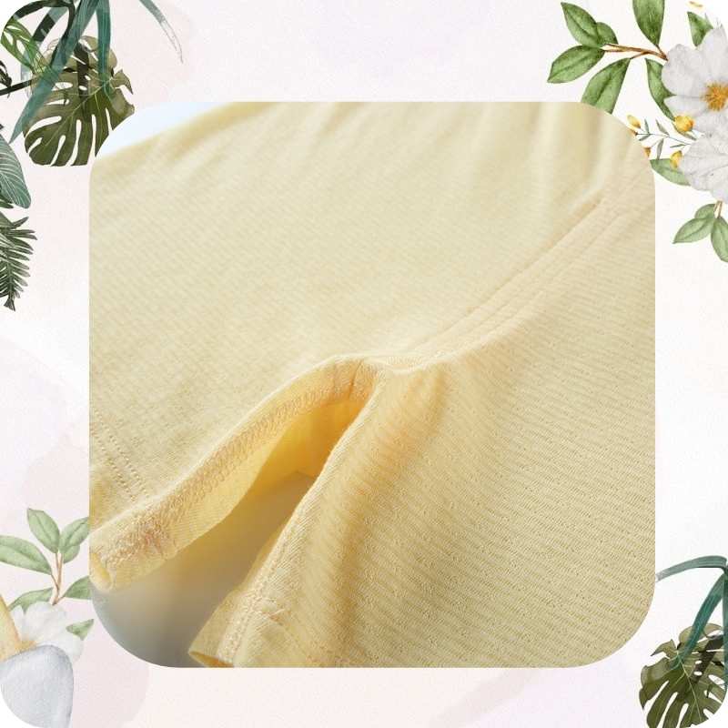 Close-up of a yellow fabric with floral and leaf decorations in the background