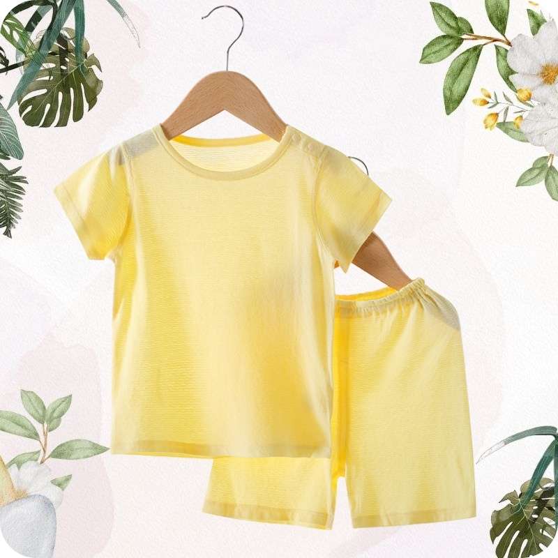 Yellow children's outfit on a hanger with a floral and leafy background