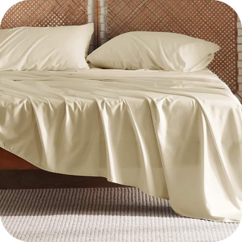 A yellow bamboo fiber bed sheet set on a bed, including a fitted sheet, pillowcase, and two additional pillowcases.