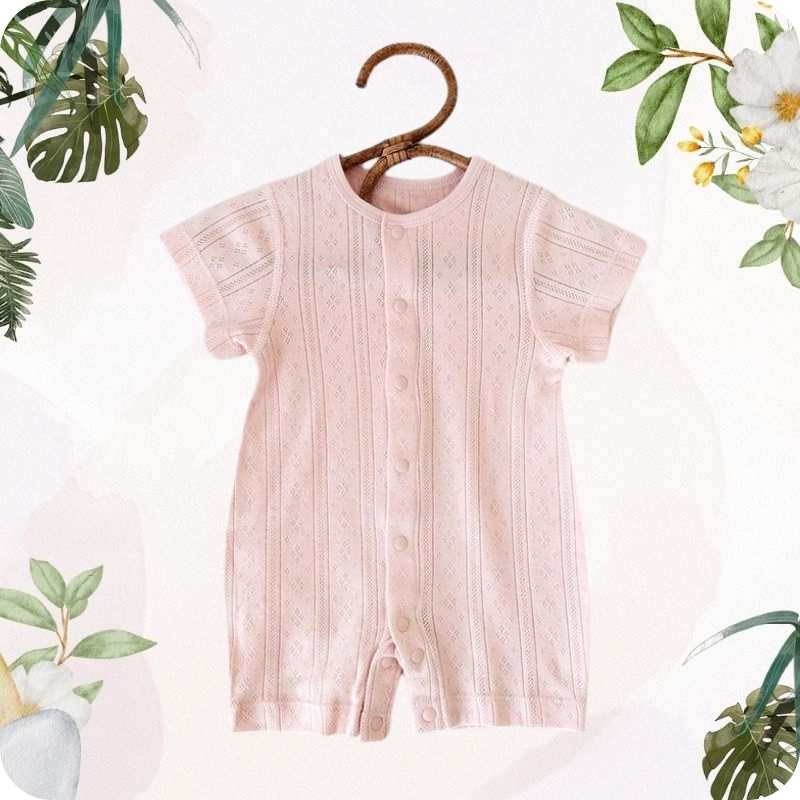 Pink baby romper on a hanger with floral and plant decorations