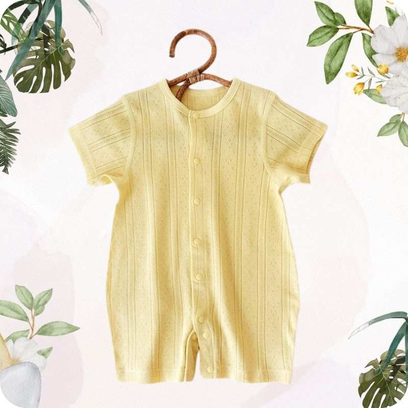 Yellow baby romper on a hanger with floral and leaf decorations
