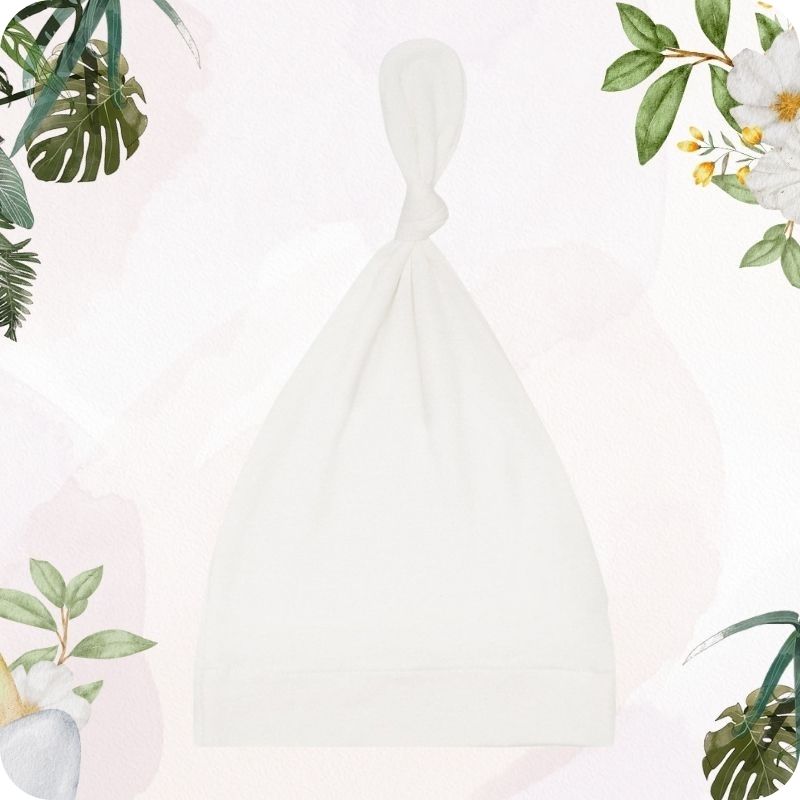 White baby swaddle with floral and leaf decorations on a light pink background