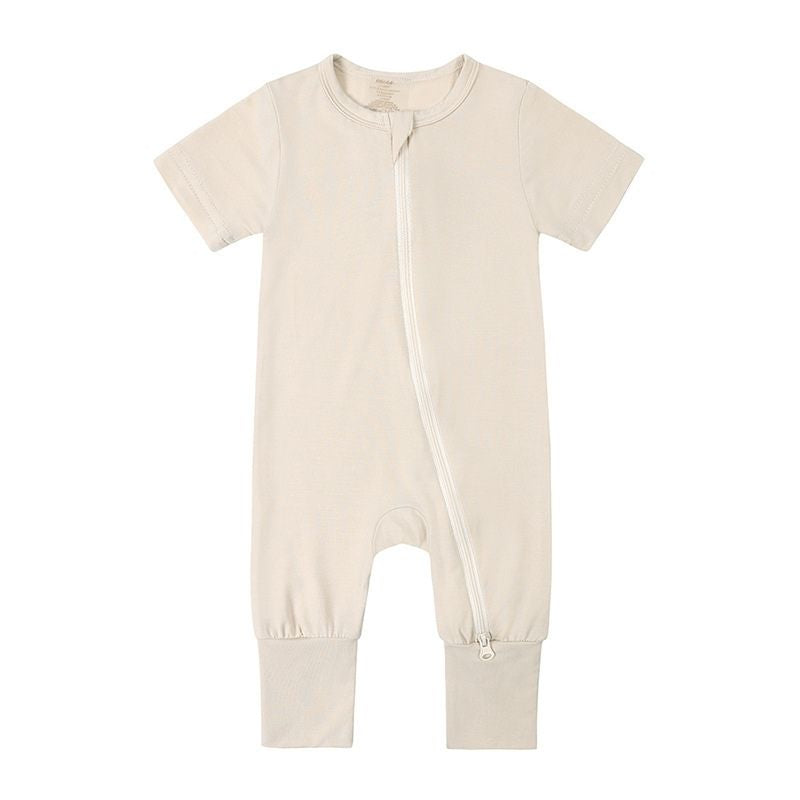 A beige baby jumpsuit with a zip-up front, short sleeves, and a casual style.