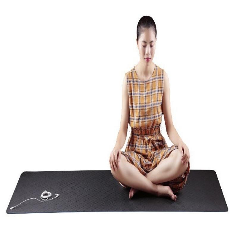Woman practicing yoga on a grounding mat, demonstrating balance, flexibility, and relaxation for wellness and mindfulness benefits.