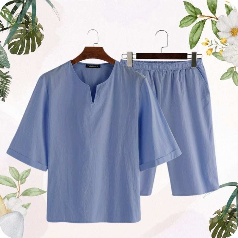 Blue shirt and shorts set on hangers with a floral and leafy border.