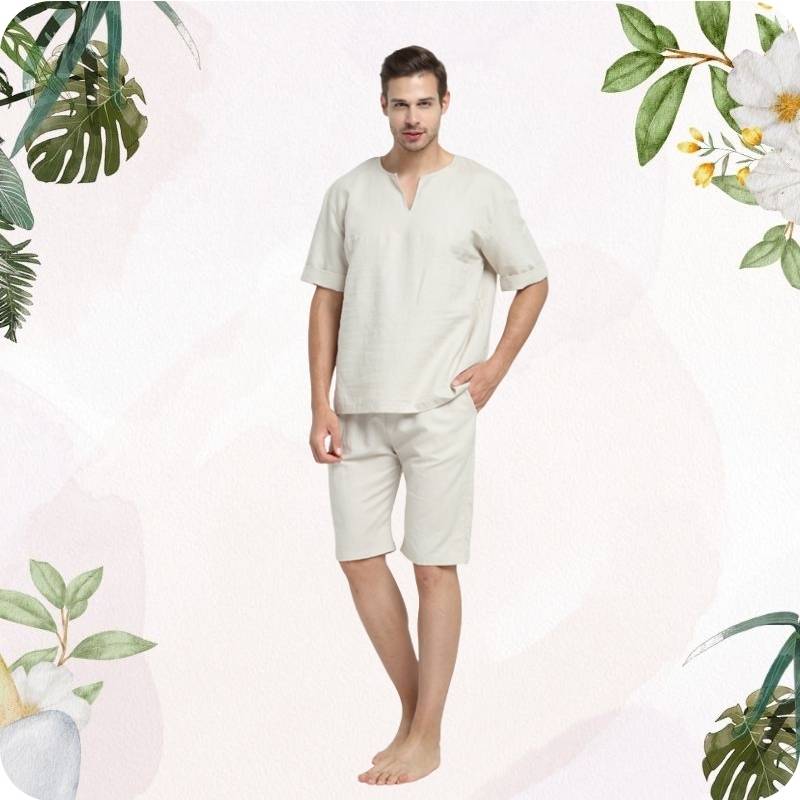 Man wearing a beige outfit with floral and leaf decorations on a light pink background