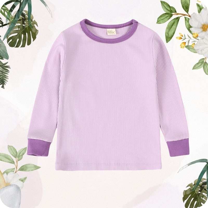 Purple ribbed long-sleeve shirt on a light pink background with floral decorations