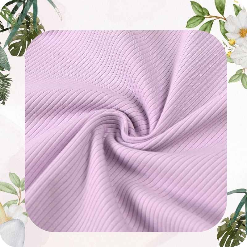 Purple textured fabric with green leaves and white flowers in the background