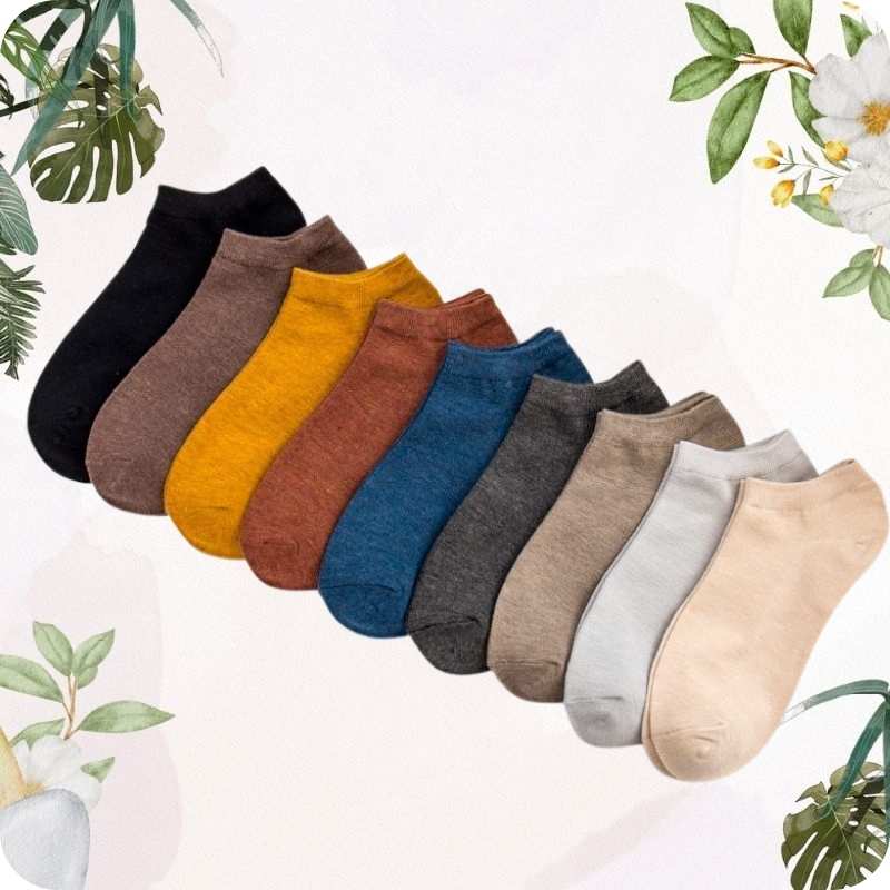 Set of colorful socks arranged in a row on a light background with floral and leaf decorations.