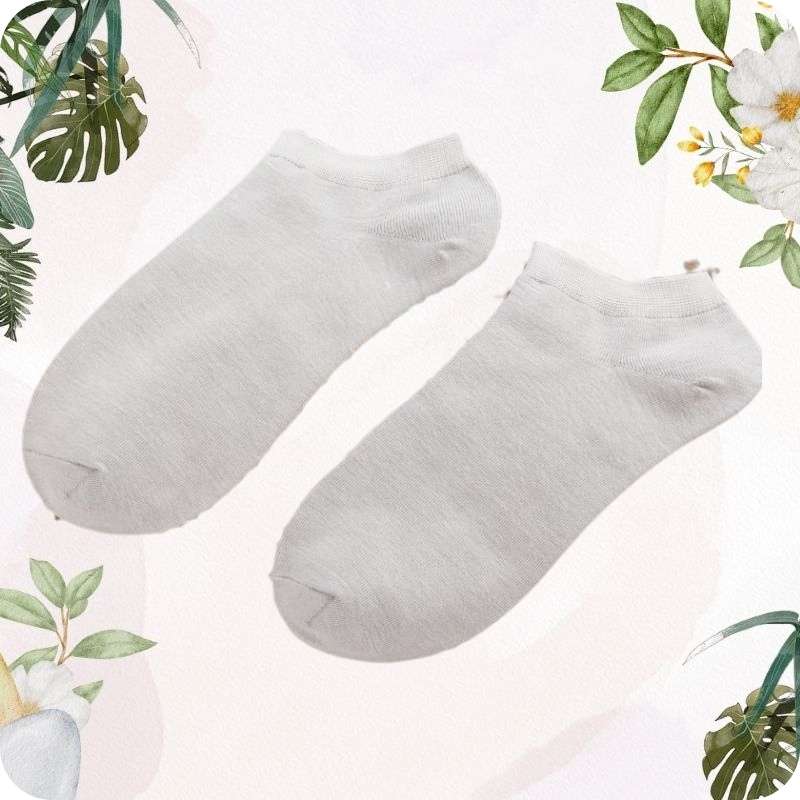 Two light gray ankle socks on a light pink background with green leafy elements.