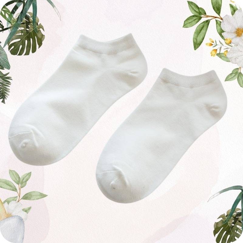 Two white ankle socks on a light pink background with floral and leaf decorations.