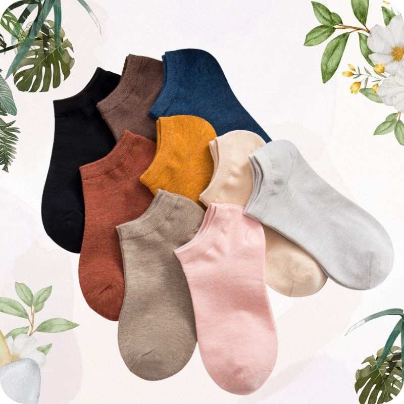 Set of colorful socks arranged on a light background with floral and leaf decorations.
