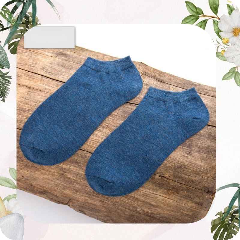 Pair of blue socks on a wooden surface with floral decorations.