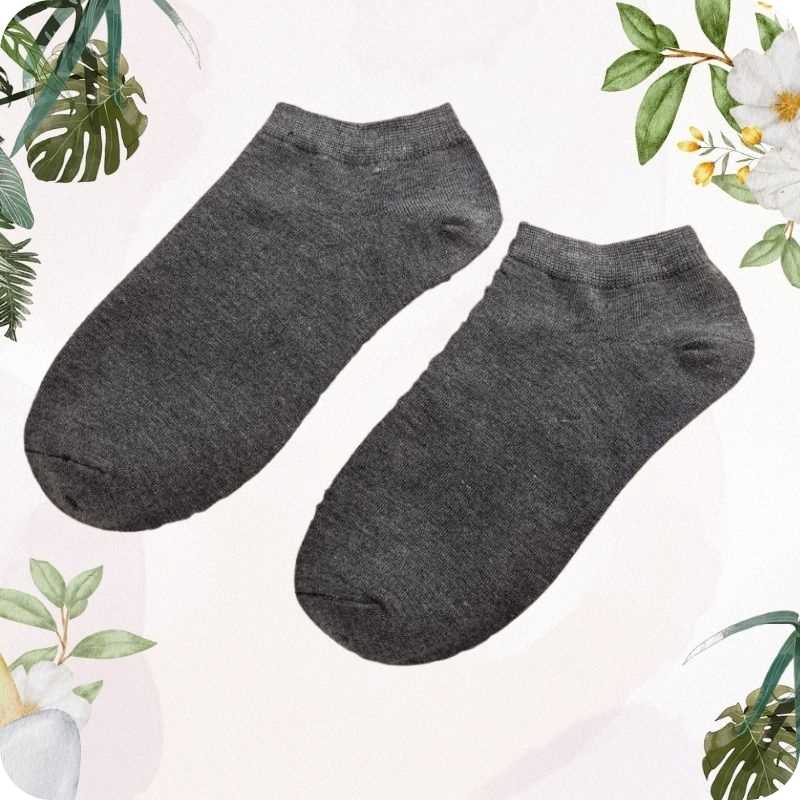 Pair of light ray ankle socks on a light background with floral and leaf decorations.
