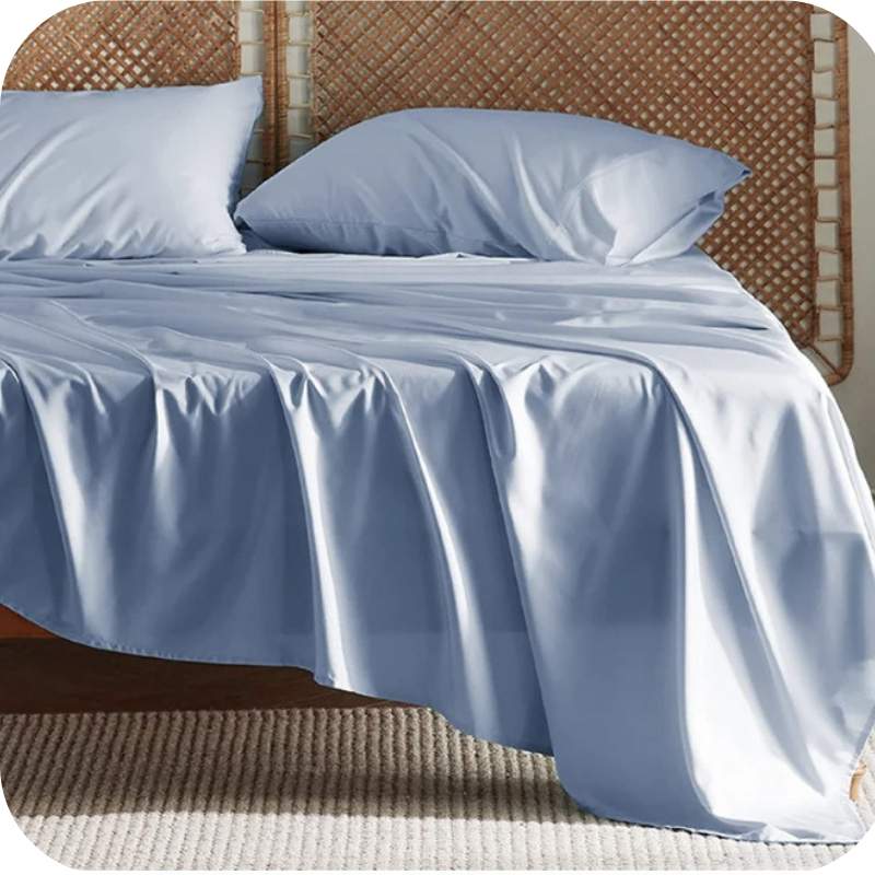 A baby blue bamboo fiber bed sheet set on a bed, including a fitted sheet, pillowcase, and two additional pillowcases.