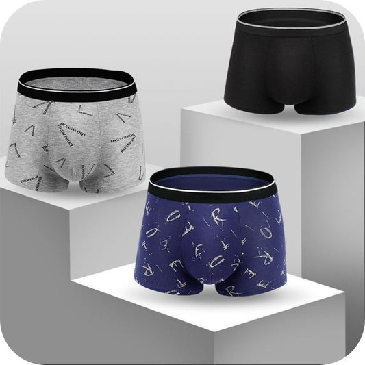 Three different pairs of men's underwear on a series of white geometric-patterned pedestals. The underwear features various colors and geometric designs.